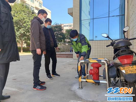 排查组对实验楼门前消防栓进行安全隐患检查